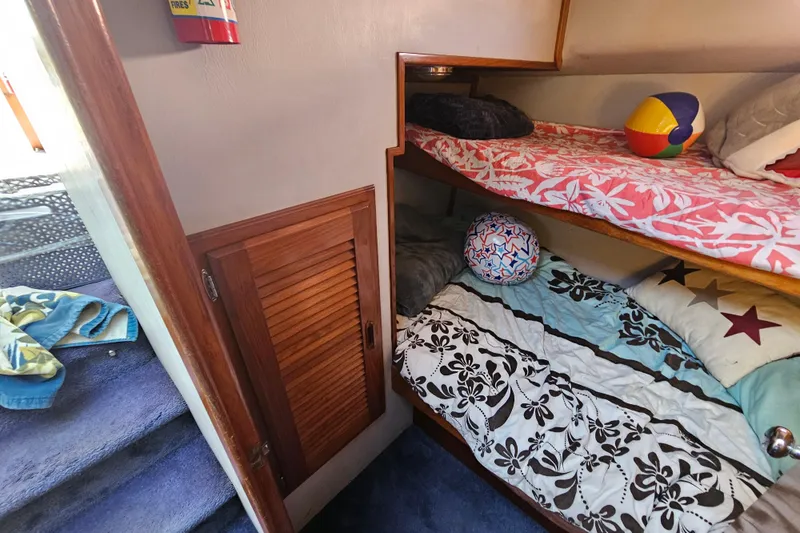 Slide: The Image of Bunk beds in a 1990 Mediterranean 38 Convertible boat cabin with colorful bedding and pillows. - 35