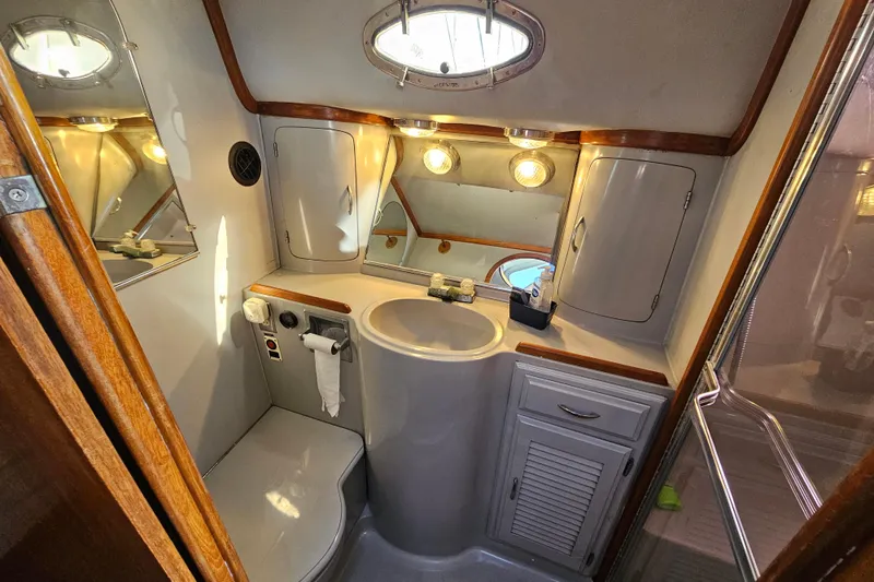 Slide: The Image of Bathroom interior of 1990 Mediterranean 38 Convertible yacht, featuring sink, mirror, and storage. - 36