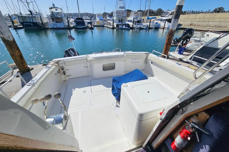 Slide: The Image of 1990 Mediterranean 38 Convertible yacht docked at marina, featuring spacious deck and seating area. - 7