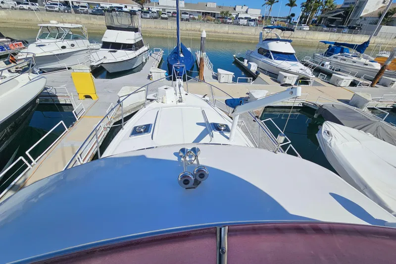 Slide: The Image of 1990 Mediterranean 38 Convertible yacht docked in a marina, surrounded by other boats. - 8