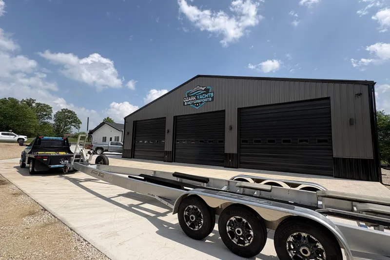Slide: The Image of Trailer outside Ozark Yachts building under a clear sky, featuring a 2022 Nor-Tech 392 Super Fish. - 18