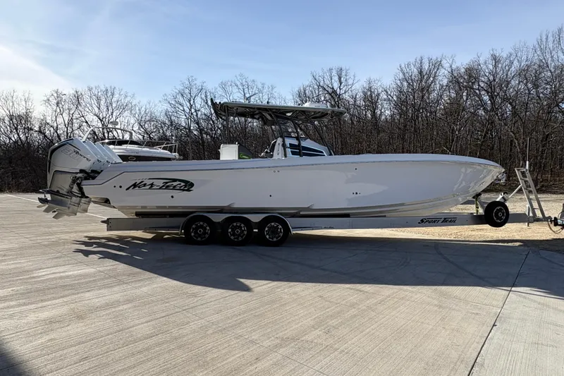 Slide: The Image of 2022 Nor-Tech 392 Super Fish boat on trailer outside a large garage. - 5