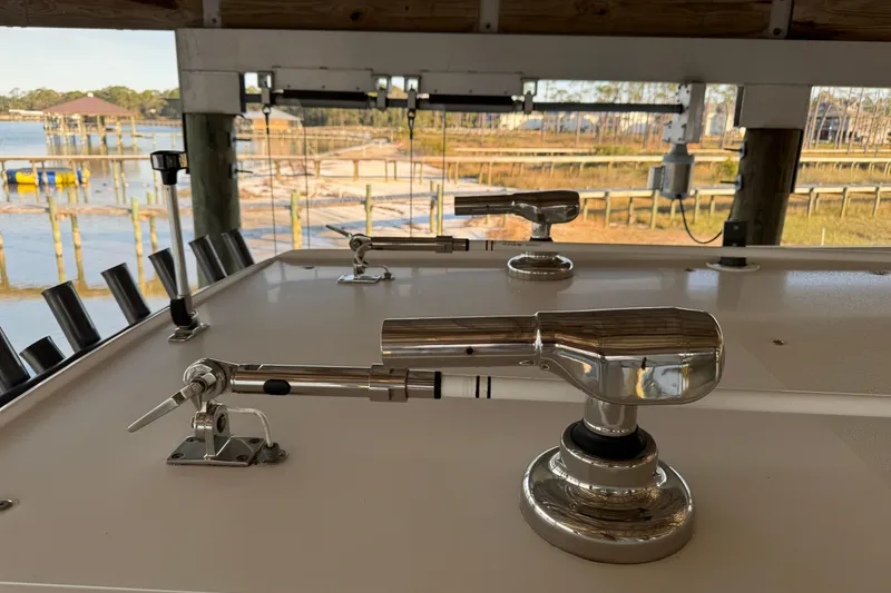 Slide: The Image of 2022 Nor-Tech 392 Super Fish boat with fishing rod holders, docked by a scenic waterfront. - 10