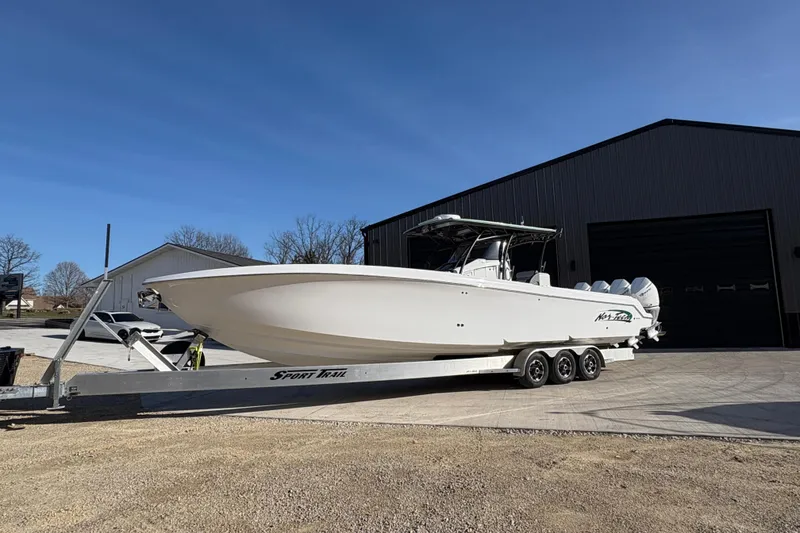 Slide: The Image of 2022 Nor-Tech 392 Super Fish boat on trailer outside a large garage. - 4