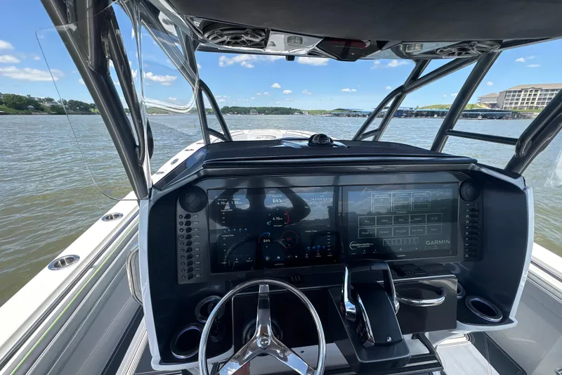 Slide: The Image of 2022 Nor-Tech 392 Super Fish boat dashboard with advanced Garmin navigation system on a sunny day. - 6