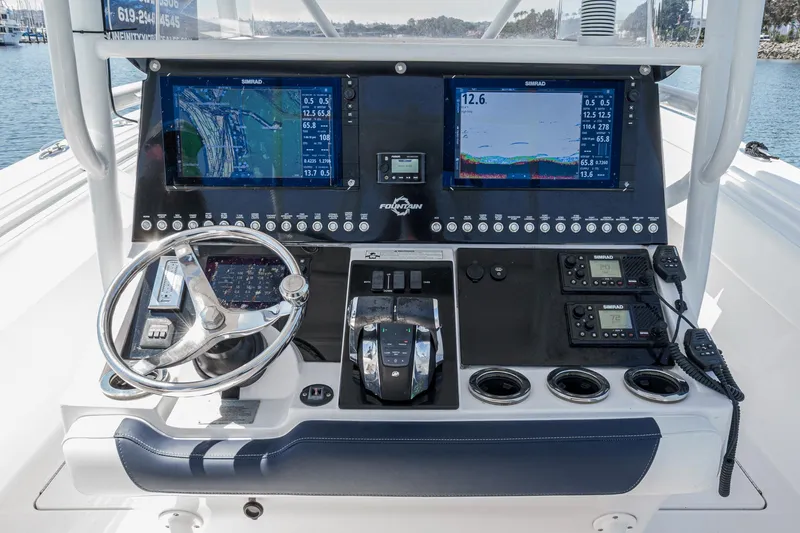 Slide: The Image of Control panel of a 2019 Fountain 38 CC boat with navigation screens and steering wheel. - 16
