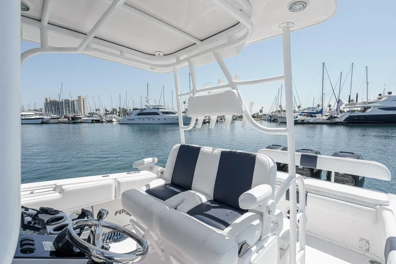 Slide: The Image of 2019 Fountain 38 CC boat interior with marina view, featuring sleek seating and steering wheel. - 21