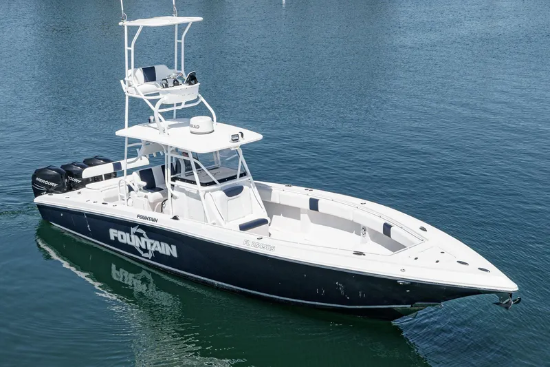 Slide: The Image of 2019 Fountain 38 CC boat on calm water, featuring sleek design and multiple outboard engines. - 46