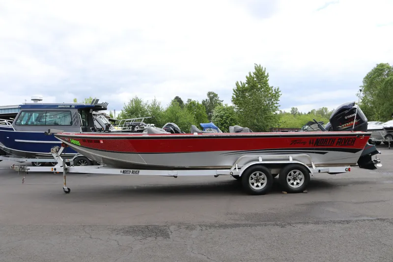 Slide: The Image of 2026 North River SCOUT boat on trailer, red and silver design, parked outdoors. - 3