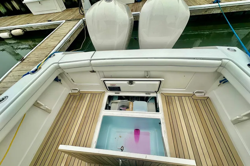 Slide: The Image of 2013 Jupiter 30 Center Console boat interior with open storage compartments at dock. - 18