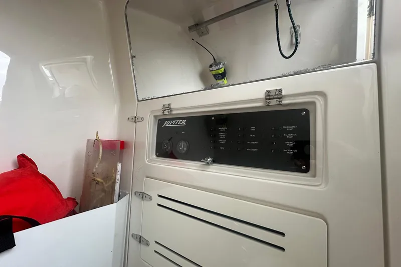 Slide: The Image of Control panel inside 2013 Jupiter 30 Center Console boat, featuring switches and storage. - 9