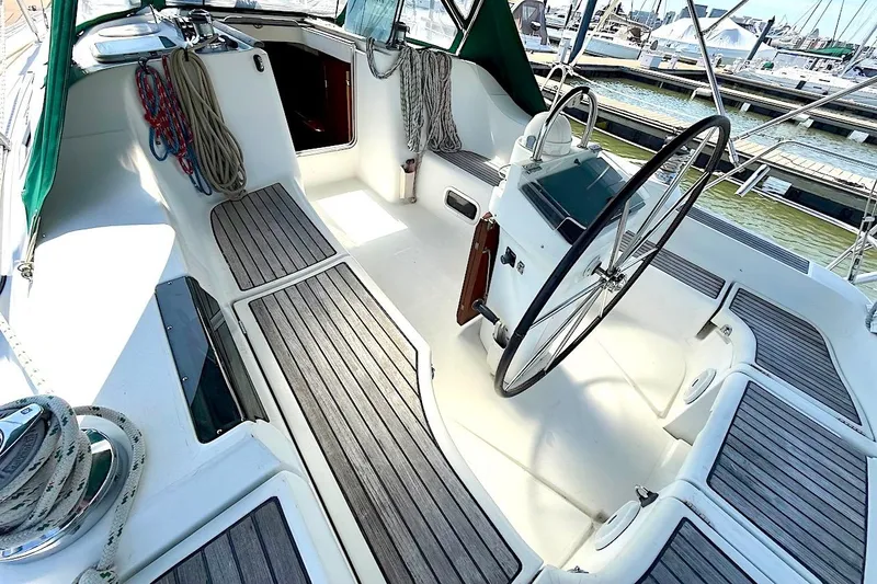 Slide: The Image of Cockpit of 2003 Beneteau 393 sailboat with steering wheel and teak flooring. - 10