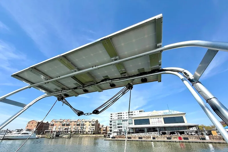 Slide: The Image of Solar panel installation on a 2003 Beneteau 393 sailboat, docked near waterfront buildings. - 11