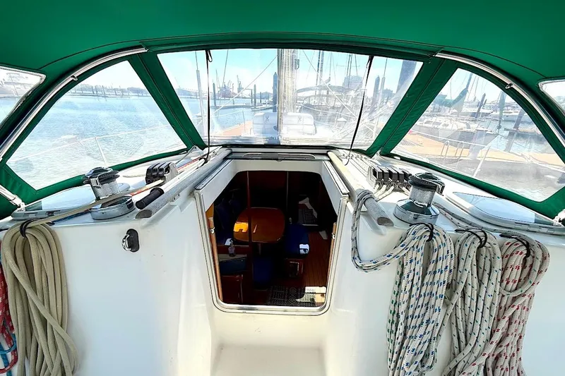Slide: The Image of 2003 Beneteau 393 sailboat cockpit with green canopy, ropes, and marina view. - 13