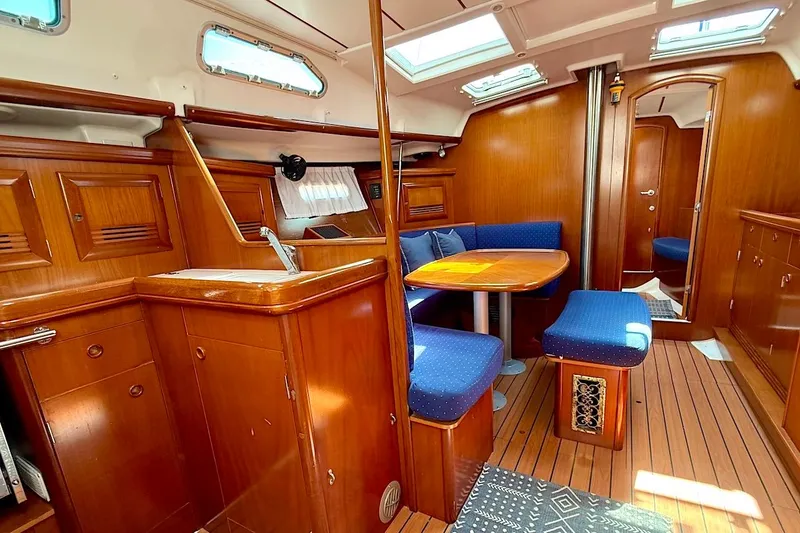 Slide: The Image of Interior of 2003 Beneteau 393 yacht with wooden cabinetry and blue upholstered seating. - 14