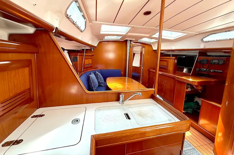 Slide: The Image of Interior of 2003 Beneteau 393 yacht with wooden finish and cozy seating area. - 15