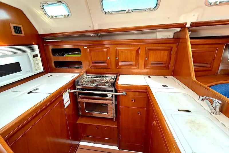 Slide: The Image of Luxurious 2003 Beneteau 393 yacht kitchen with wood cabinetry and modern appliances. - 16