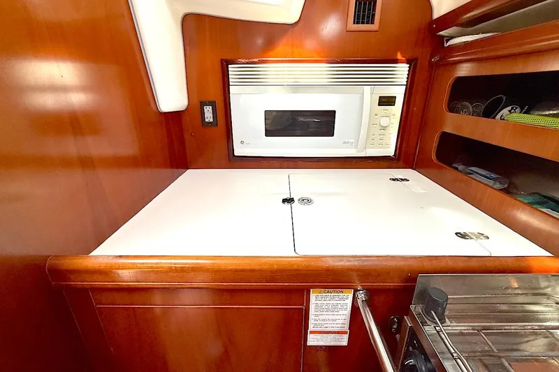 Slide: The Image of Galley area of 2003 Beneteau 393 yacht with microwave and storage compartments. - 17