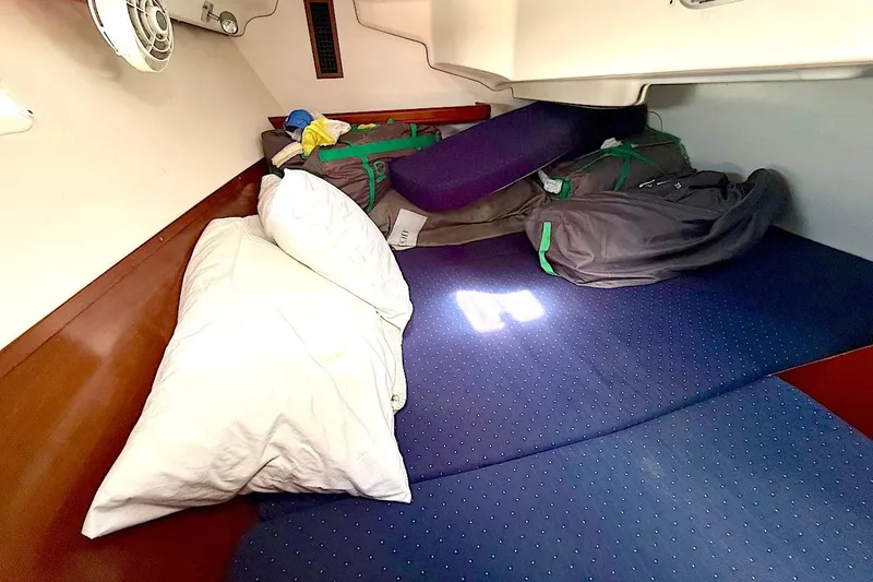 Slide: The Image of Cozy cabin interior of 2003 Beneteau 393 sailboat with bedding and storage bags. - 19
