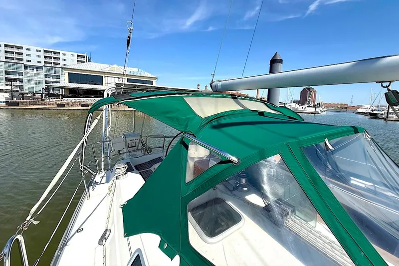 Slide: The Image of 2003 Beneteau 393 sailboat with green canopy docked in a marina. - 7