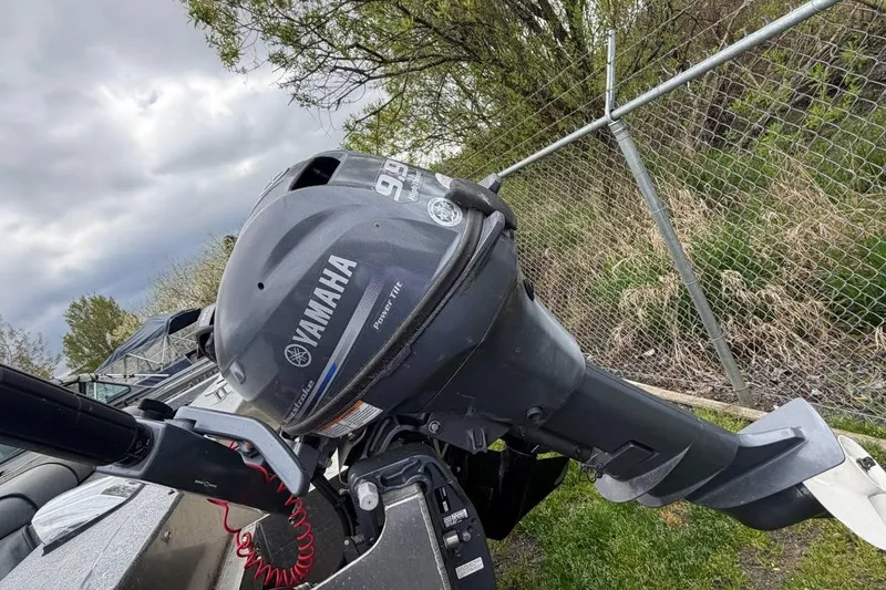 Slide: The Image of 2004 Alumaweld STRYKER 19 with Yamaha outboard motor, parked near a chain-link fence. - 15