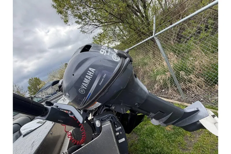 Slide: The Image of 2004 Alumaweld STRYKER 19 boat with Yamaha outboard motor, parked near a chain-link fence. - 7