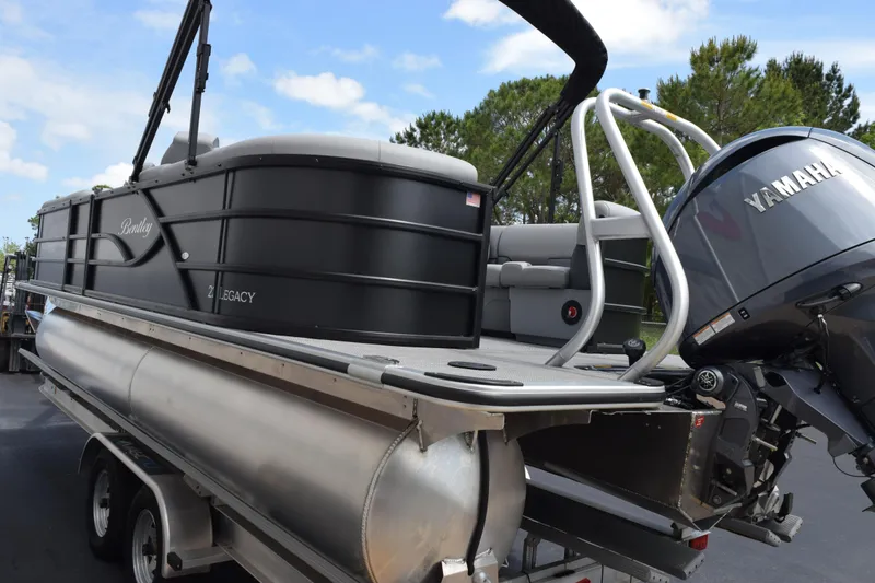 Slide: The Image of 2026 Bentley Pontoons Legacy 223 Navigator with Yamaha engine, parked on a trailer. - 6