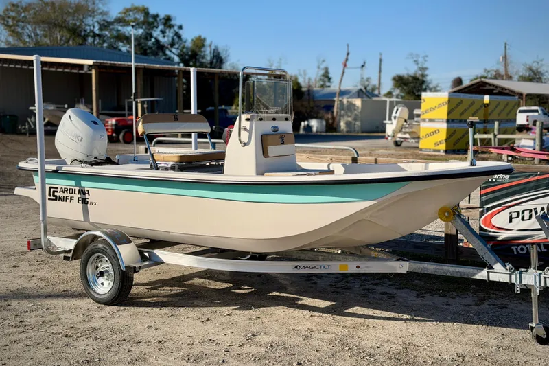 The Image of 2026 Carolina Skiff E16 JVX CC boat on trailer, parked outdoors. - 0