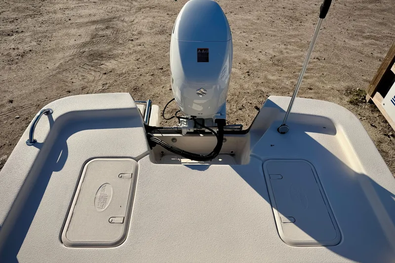 Slide: The Image of 2026 Carolina Skiff E16 JVX CC boat stern with outboard motor and storage compartments. - 12