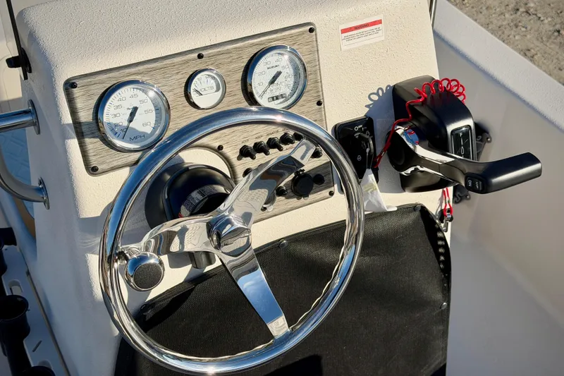 Slide: The Image of 2026 Carolina Skiff E16 JVX CC boat dashboard with steering wheel and controls. - 14