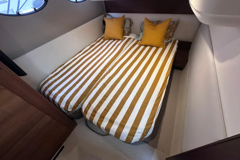 Slide: The Image of Twin beds with striped bedding in a 2018 Princess F43 yacht cabin. - 10