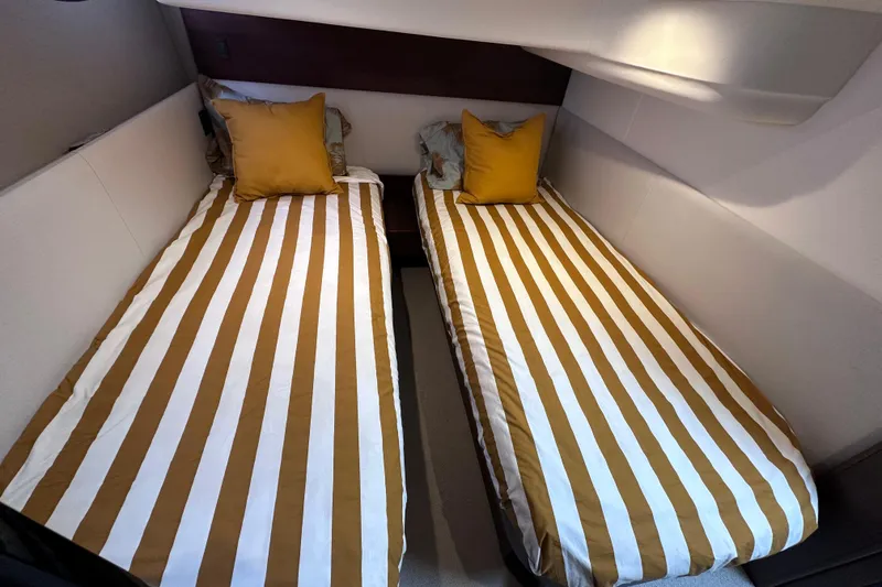 Slide: The Image of Twin beds with striped bedding in a 2018 Princess F43 yacht cabin. - 9