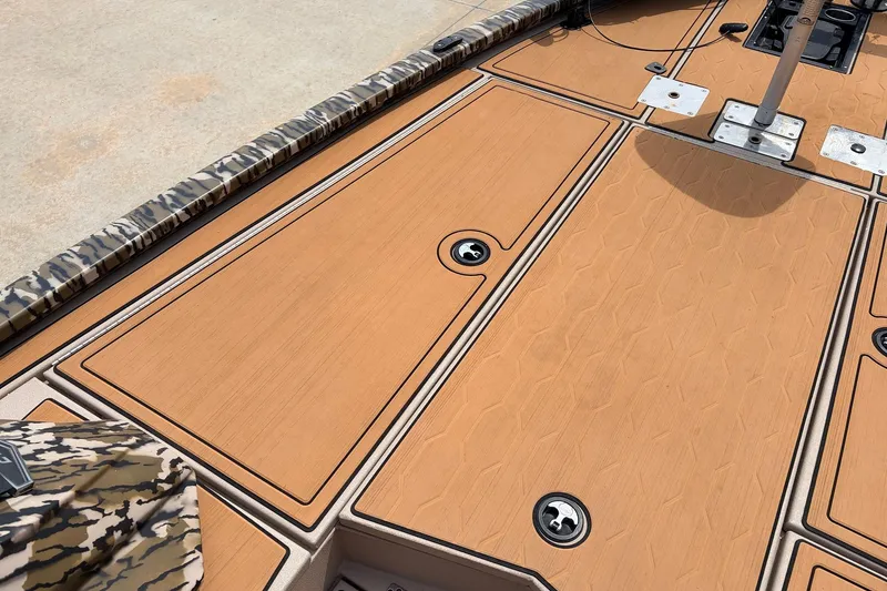 Slide: The Image of 2023 Avid 21 XB Elite boat deck with camo accents and storage compartments. - 16