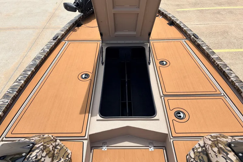 Slide: The Image of 2023 Avid 21 XB Elite boat deck with open storage compartments and camouflage trim. - 19
