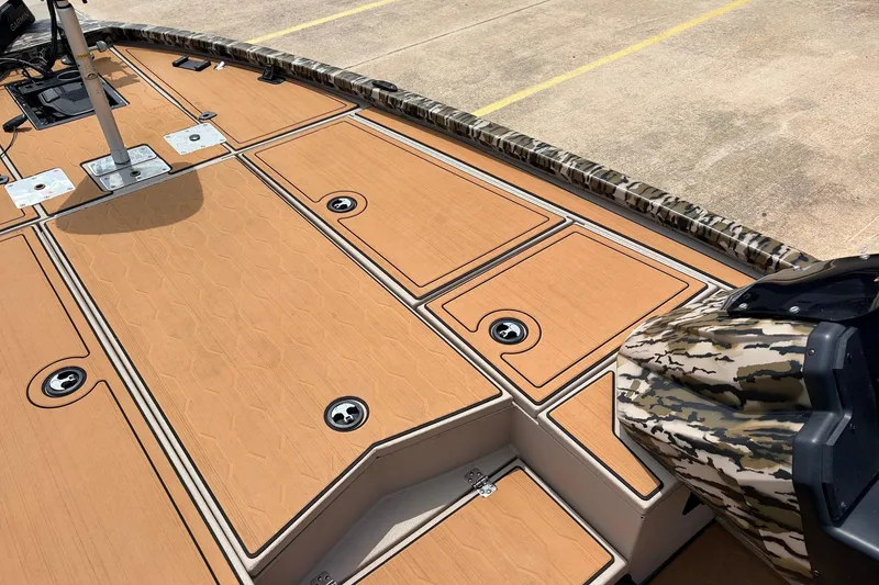 Slide: The Image of 2023 Avid 21 XB Elite boat deck with camo accents and storage compartments. - 21