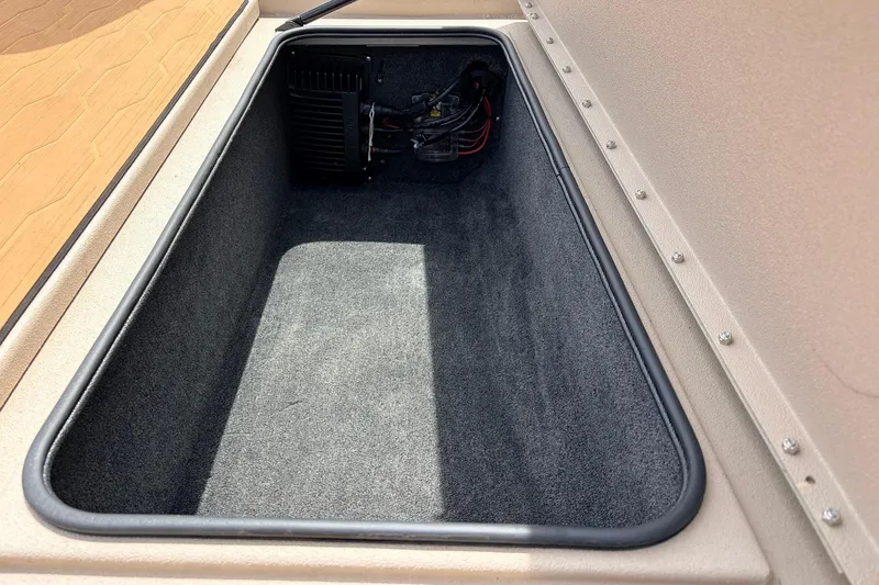 Slide: The Image of Storage compartment of 2023 Avid 21 XB Elite boat, featuring carpeted interior and wiring. - 23