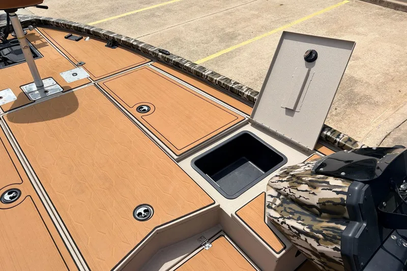 Slide: The Image of 2023 Avid 21 XB Elite boat deck with storage compartments and camouflage motor cover. - 24