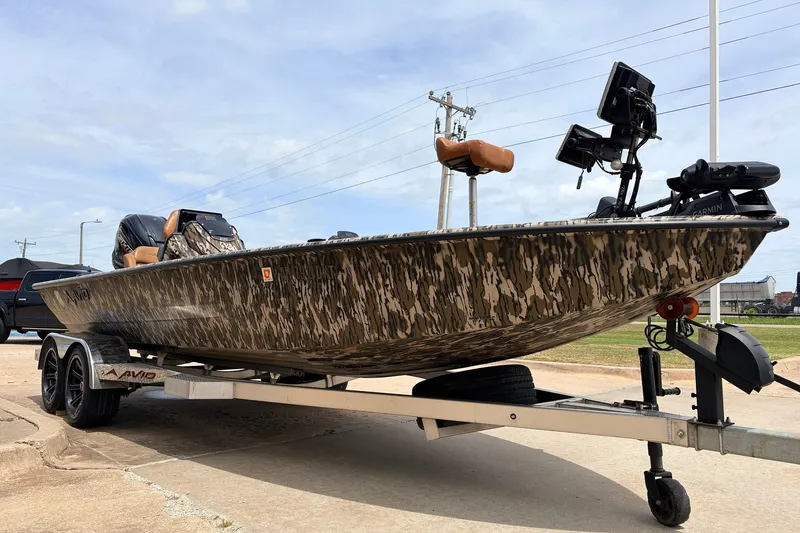 Slide: The Image of 2023 Avid 21 XB Elite boat with camouflage design on a trailer. - 3