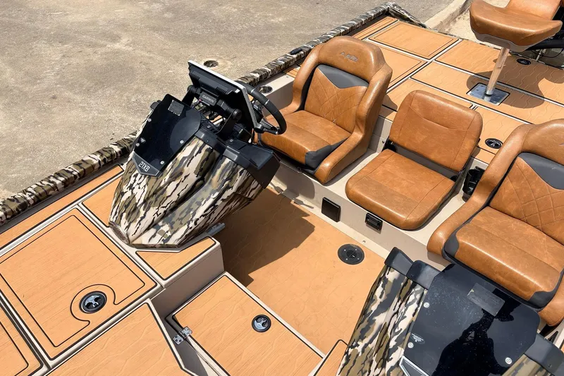 Slide: The Image of 2023 Avid 21 XB Elite boat interior with tan leather seats and camouflage console. - 30