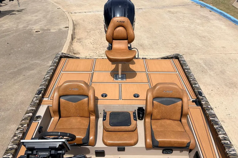 Slide: The Image of 2023 Avid 21 XB Elite boat interior with tan leather seats and Garmin equipment. - 41