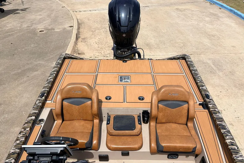 Slide: The Image of 2023 Avid 21 XB Elite boat interior with tan seats and Garmin equipment. - 42