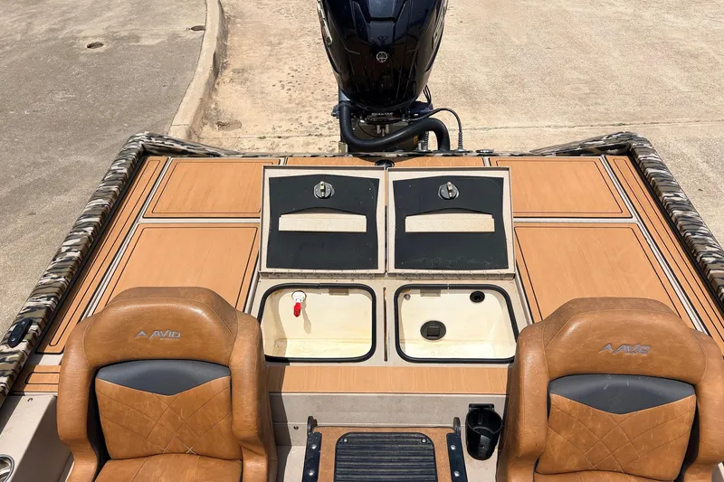Slide: The Image of 2023 Avid 21 XB Elite boat interior with tan seats and storage compartments. - 43