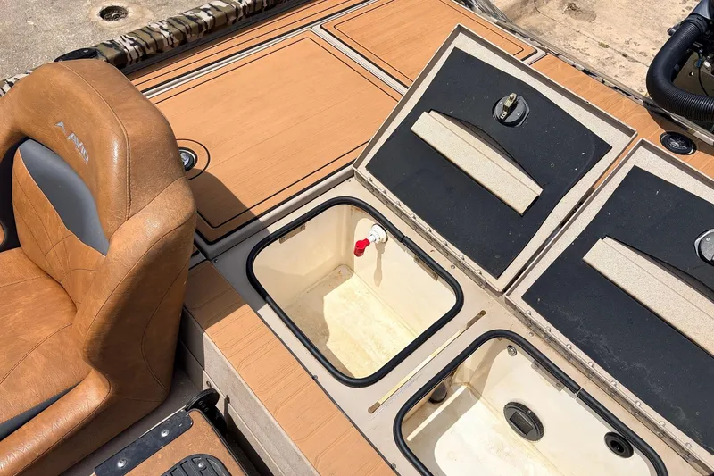 Slide: The Image of 2023 Avid 21 XB Elite boat interior with storage compartments and tan seating. - 44