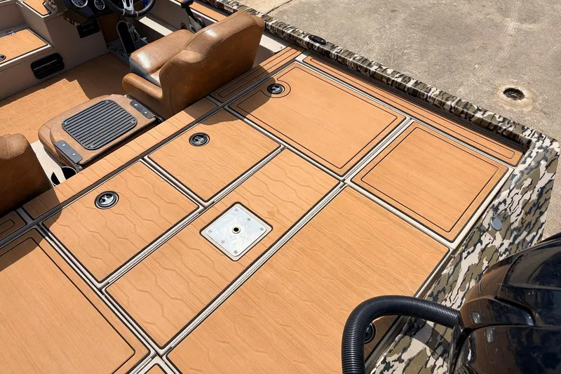 Slide: The Image of 2023 Avid 21 XB Elite boat interior with tan seating and camo accents. - 47