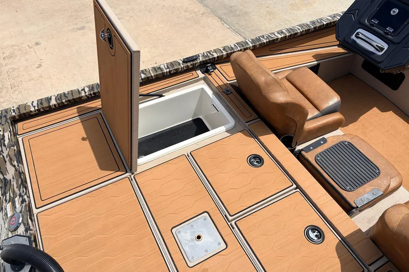 Slide: The Image of 2023 Avid 21 XB Elite boat interior with open storage compartment and brown seating. - 49