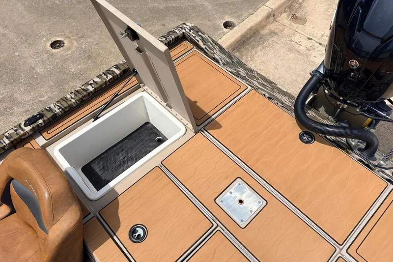Slide: The Image of 2023 Avid 21 XB Elite boat deck with open storage compartment and motor. - 51