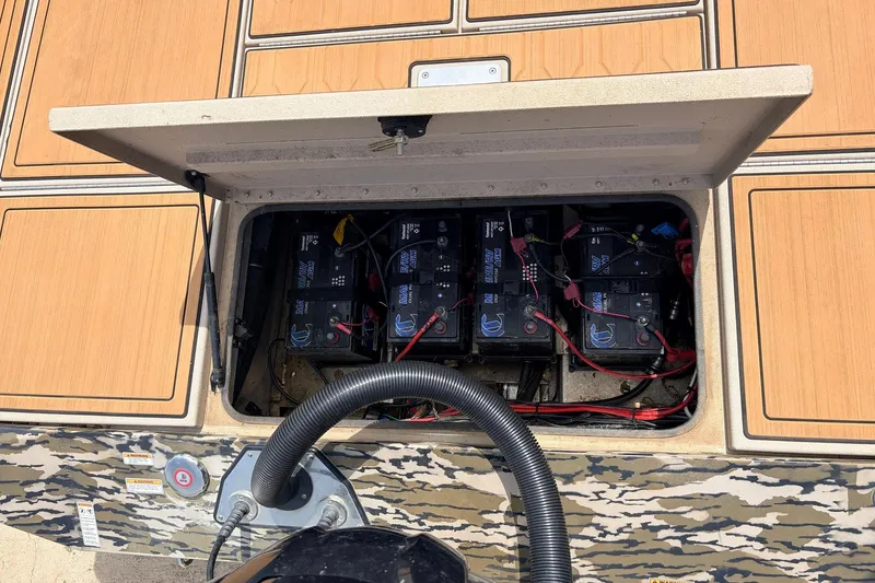 Slide: The Image of Open battery compartment of 2023 Avid 21 XB Elite boat, showing multiple batteries and wiring. - 52