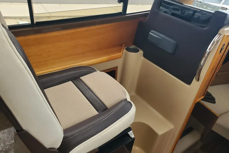 Slide: The Image of Interior seating of a 2016 Cutwater 28 boat with wood accents and cup holder. - 2