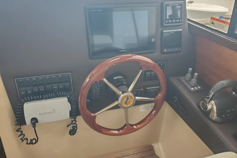 Slide: The Image of Helm of 2016 Cutwater 28 boat with Garmin navigation and wooden steering wheel. - 3