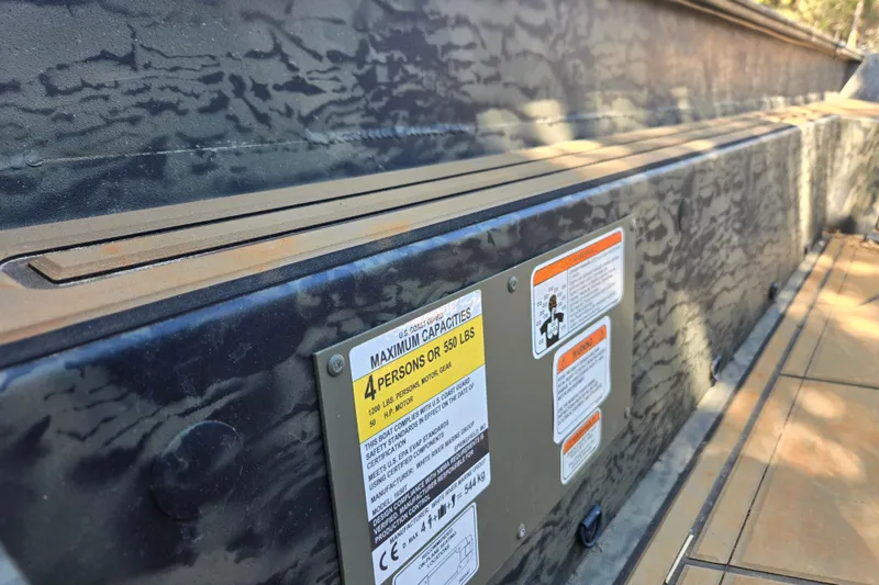 Slide: The Image of 2026 Tracker Grizzly 1650 T Prairie Wings Edition boat capacity label and interior detail. - 7